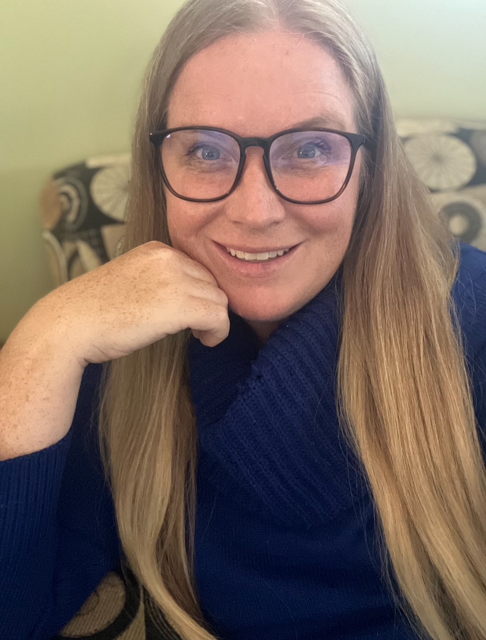 Krista Lynne Capstick, a Registered Psychotherapist, smiling warmly in a navy sweater