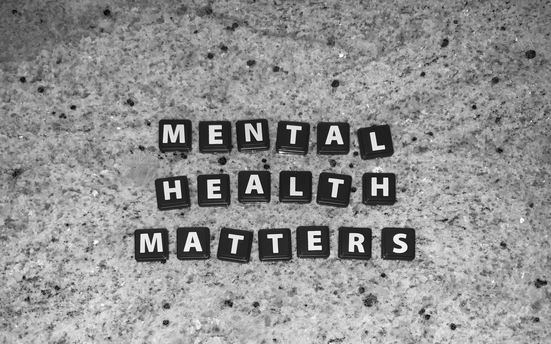 Letter tiles spelling out Mental Health Matters on a granite countertop